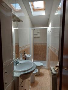 a bathroom with a sink and a toilet and a skylight at Apartamentos casa Carola in Viodo