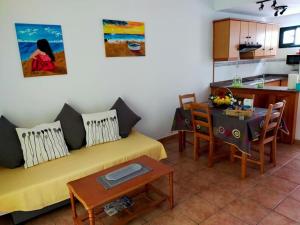 sala de estar con sofá amarillo y mesa en Casa Leiva en Punta de Mujeres