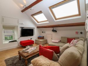 a living room with a couch and a tv at Apartment 2, Gorwel Glas in Pwllheli