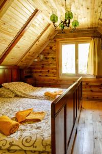 a bedroom in a log cabin with a bed at Brvnare 3 zvezde brvnara Veljko in Kokin Brod