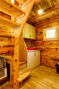 Cabaña de madera con cocina con paredes de madera y escaleras. en Brvnare 3 zvezde brvnara Veljko en Kokin Brod