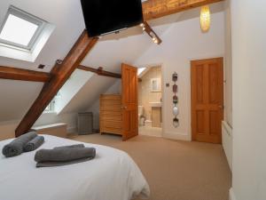 a bedroom with a bed with a tv on top at Apartment 2, Gorwel Glas in Pwllheli