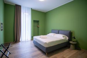 una camera verde con un letto e una finestra di Palazzo Zippitelli Apartments a Bari