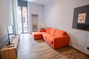a living room with an orange couch and a television at Palazzo Zippitelli Apartments in Bari