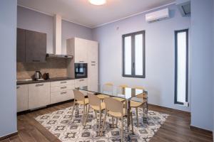 a kitchen with a glass table and chairs at Palazzo Zippitelli Apartments in Bari