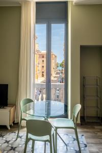 a glass table and chairs in a room with a window at Palazzo Zippitelli Apartments in Bari