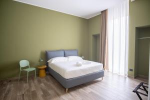 a bedroom with a bed and a chair in it at Palazzo Zippitelli Apartments in Bari