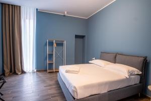 a bedroom with blue walls and a large bed at Palazzo Zippitelli Apartments in Bari