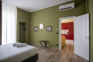 a bedroom with green walls and a bed and a door at Palazzo Zippitelli Apartments in Bari