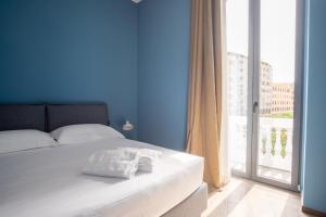 a bedroom with a white bed and a large window at Palazzo Zippitelli Apartments in Bari