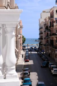 een uitzicht op een straat met geparkeerde auto's en de oceaan bij Palazzo Zippitelli Apartments in Bari
