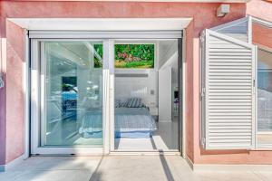 a sliding glass door with a bed in a room at The Pink Elephant Hotel in Sant Feliu de Guíxols