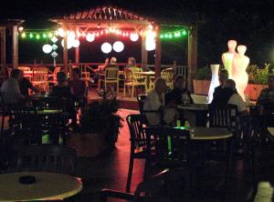 a group of people sitting at tables in a restaurant at night at Marina Hotel in Ayia Napa +37 photos