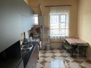 a kitchen with a sink and a table and a window at ElMar Guesthouse in Sevan
