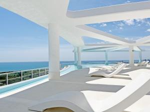 een balkon met witte stoelen en de oceaan bij Global Properties, Apartamento para 6 personas con terraza in Canet de Berenguer