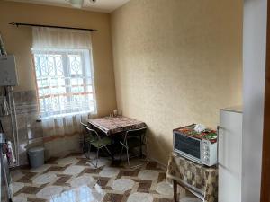 a kitchen with a table and a small table with a microwave at ElMar Guesthouse in Sevan +15 photos