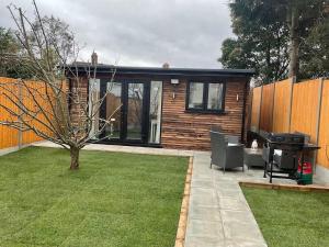 eine kleine Hütte mit Rasen und Grill in der Unterkunft Studio - Sleeps 2 - Pet friendly - Parking in Hendon + 2 Fotos