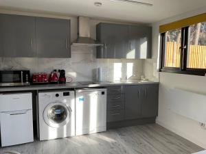 uma cozinha com uma máquina de lavar roupa e uma máquina de lavar roupa em Captivating 1-Bed Studio in London em Hendon