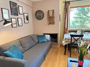 Apartamentos Confort Formigal 3000 في فورميغال: غرفة معيشة مع أريكة وطاولة وغرفة طعام