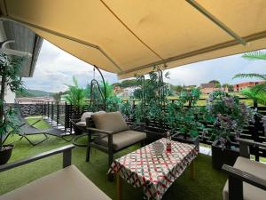 eine Terrasse mit Tisch, Stühlen und Pflanzen in der Unterkunft Tessa Apartment in Floreşti