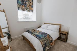 1 dormitorio con cama y ventana en BOBIN ROW - Grade 2 Listed Property with a Beautiful Design with Access to Leeds, en Leeds
