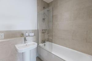 y baño con ducha, lavabo y bañera. en BOBIN ROW - Grade 2 Listed Property with a Beautiful Design with Access to Leeds, en Leeds
