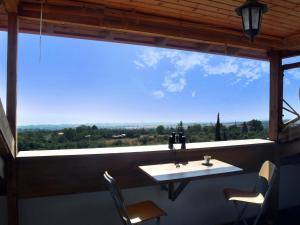 a table and chairs in a room with a large window at Panorama Loft - quality, view, sea & mountain in Litochoro