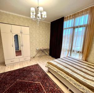 ein Schlafzimmer mit einem großen Bett und einem großen Fenster in der Unterkunft Сдается коттедж на берегу озера Иссык Куль in Chon-Sary-Oy