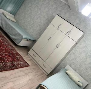 ein Schlafzimmer mit einem Bett, einem Schrank und einem Teppich in der Unterkunft Сдается коттедж на берегу озера Иссык Куль in Chon-Sary-Oy