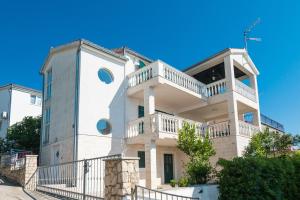 un gran edificio blanco con balcones. en Rimagis Apartments en Zaboric