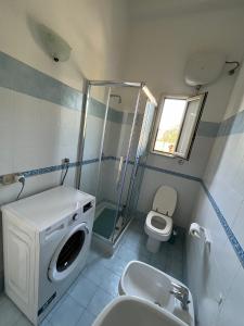 a bathroom with a washing machine and a toilet at A 2 passi dal mare - grazioso trilocale a Locri in Locri