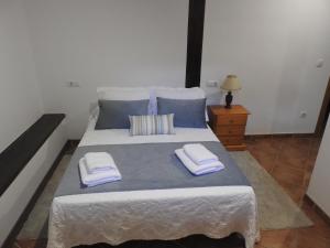 a bedroom with a large bed with two towels on it at CASUCA LA SOLANA in Potes