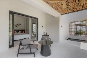 1 dormitorio con 1 cama, mesa y sillas en The Jing, en Tejakula
