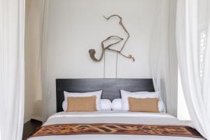 a bed with a black headboard in a bedroom at The Jing in Tejakula