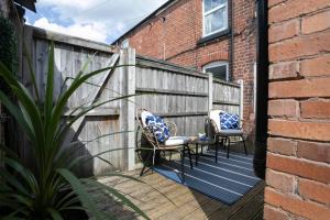 trois chaises assises sur une terrasse à côté d'une clôture dans l'établissement *Central 2 bed - Sleeps 5*, à Chesterfield