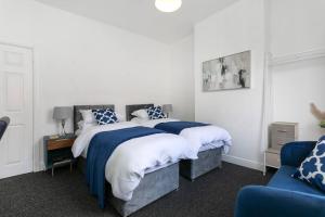1 dormitorio con 1 cama con almohadas azules y blancas en *Central 2 bed - Sleeps 5* en Chesterfield