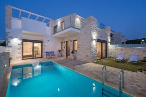 a villa with a swimming pool and a house at Megalith Villas in Agia Marina Nea Kydonias