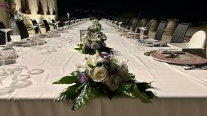 a long white table with flowers on it at Locanda Gulfi in Chiaramonte Gulfi +96 photos