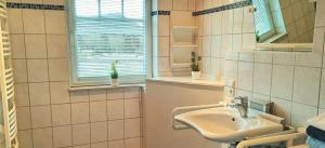 ヴェルドゥムにあるAm Osthörn rollstuhlgerechtの洗面台と窓のあるバスルーム +9枚の写真