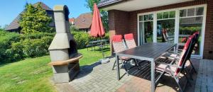 ヴェルドゥムにあるAm Osthörn rollstuhlgerechtのパティオ(テーブル、椅子、暖炉付)