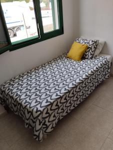 a bed with a black and white blanket and two pillows at Crismela in Yaiza