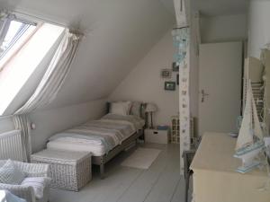 a attic room with two beds and a window at Inspektorenhaus am Jagdschloss mit Meerblick in Hohen Niendorf