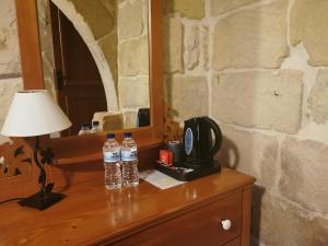 dos botellas de agua sentadas en un tocador junto a un espejo en Bed and breakfast "Selena" with swim pool, en Nadur