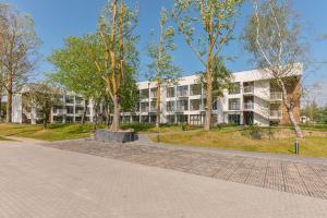 an apartment building with trees in front of it at GRANO FLATS - Sobieszewo - Baltic Porto in Gdańsk