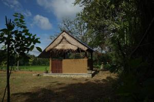 a small hut with a thatched roof in a field at Agoura Hills in Kurunegala