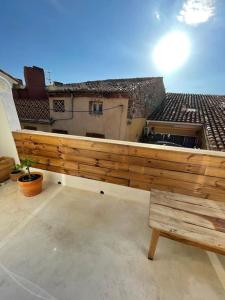 a balcony with a wooden fence and a bench at Superbe duplex à 5 min de la plage in Torreilles
