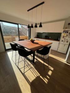 a large kitchen with a wooden table and chairs at Superbe duplex à 5 min de la plage in Torreilles