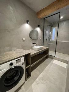 a bathroom with a washing machine and a sink at Superbe duplex à 5 min de la plage in Torreilles