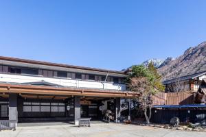 an exterior view of a building with mountains in the background at Hirayukan in Takayama