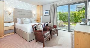 um quarto de hotel com uma cama e uma varanda em Knockendarroch Hotel em Pitlochry